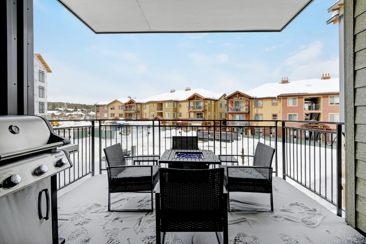 A welcoming outdoor dining area featuring a table and grill, set against a backdrop of snow and nearby buildings. The space suggests memorable winter gatherings, barbecues, and enjoying the outdoors even in colder months.