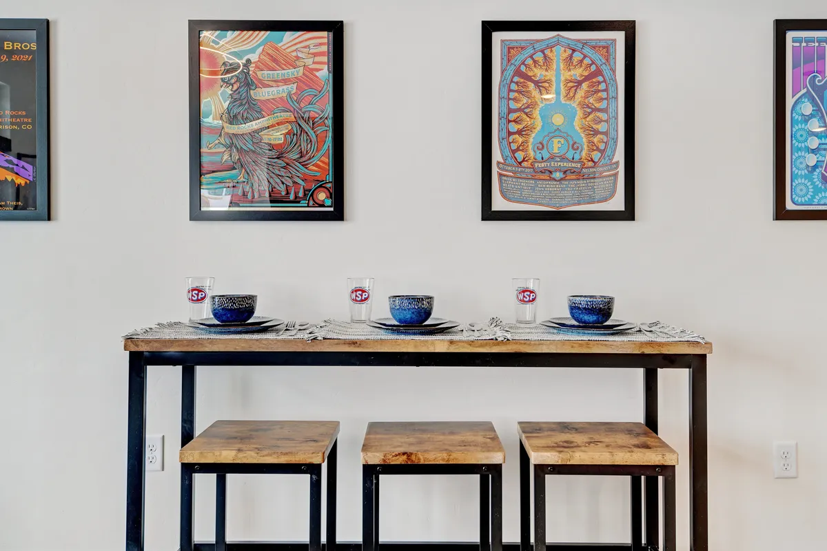 A creative dining area with a stylish table set for a meal, framed artwork on the walls, and an inviting, relaxed ambiance. The focus is on the connection between art, dining, and social gatherings.